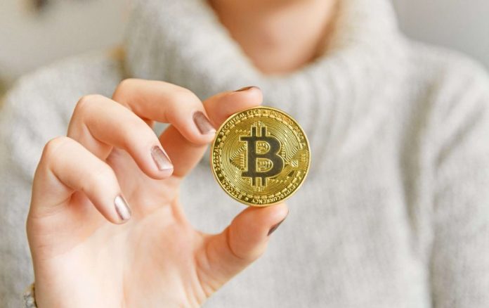 Picture of a hand holding a bitcoin